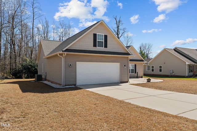 view of front of house featuring a garage, a shingled roof, concrete driveway, central AC, and a front yard