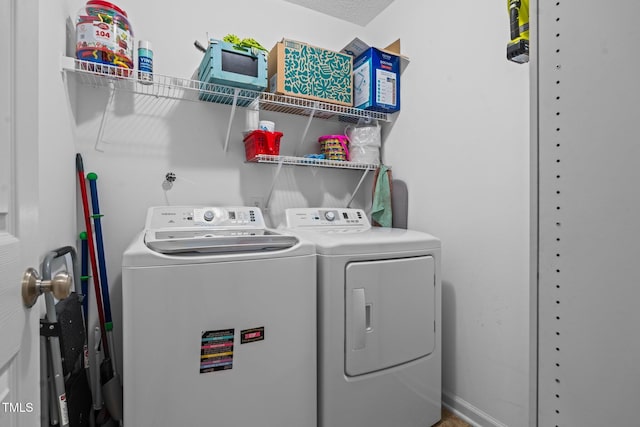 washroom featuring laundry area, washer and clothes dryer, and baseboards