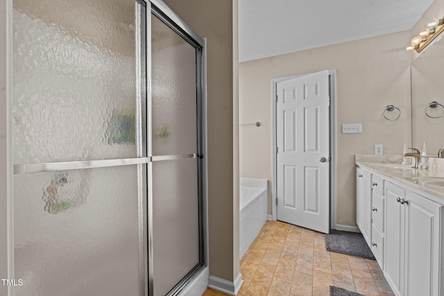 full bathroom featuring baseboards, a garden tub, a shower stall, and vanity