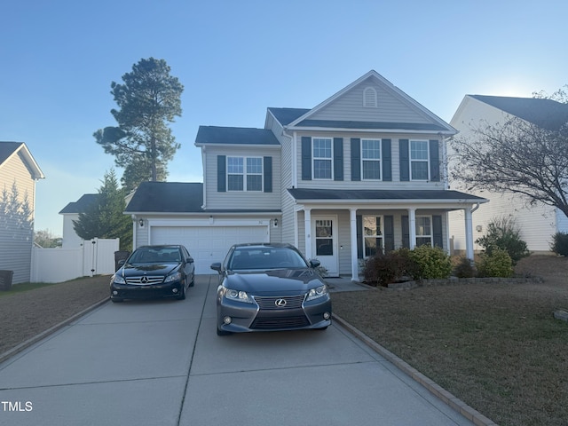 traditional-style house featuring concrete driveway and fence