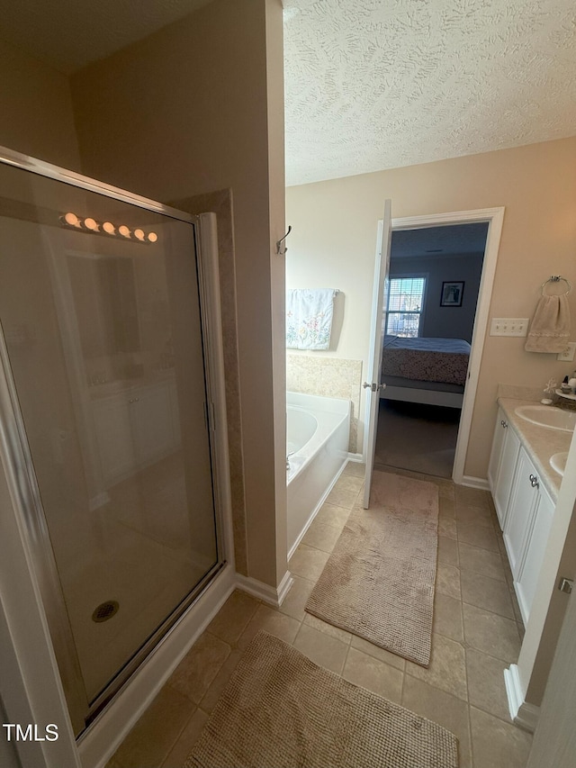 ensuite bathroom featuring a stall shower, a textured ceiling, vanity, tile patterned flooring, and a bath