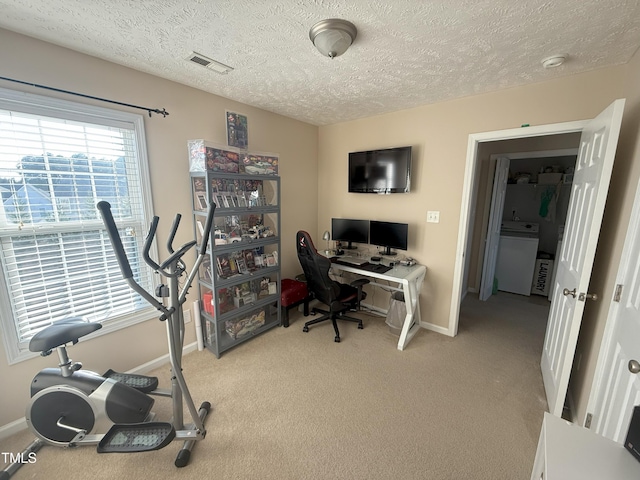 office area featuring light colored carpet, visible vents, and a textured ceiling