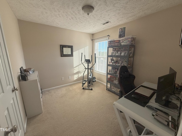 carpeted office with a textured ceiling, visible vents, and baseboards