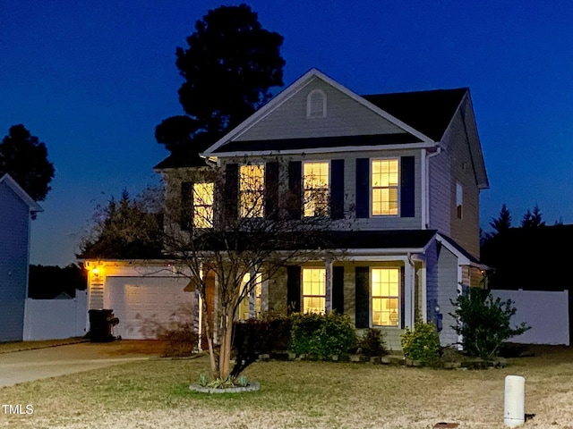 traditional home with a garage and a lawn