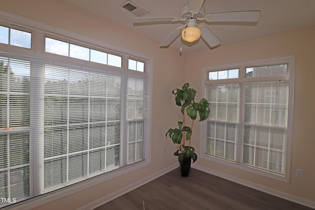 unfurnished sunroom featuring a ceiling fan, visible vents, and plenty of natural light