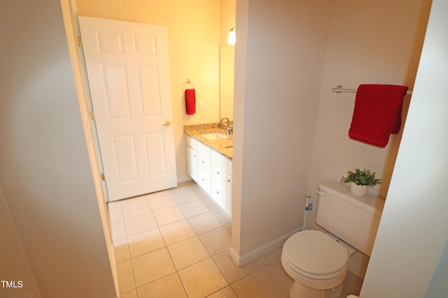 bathroom with toilet, vanity, baseboards, and tile patterned floors