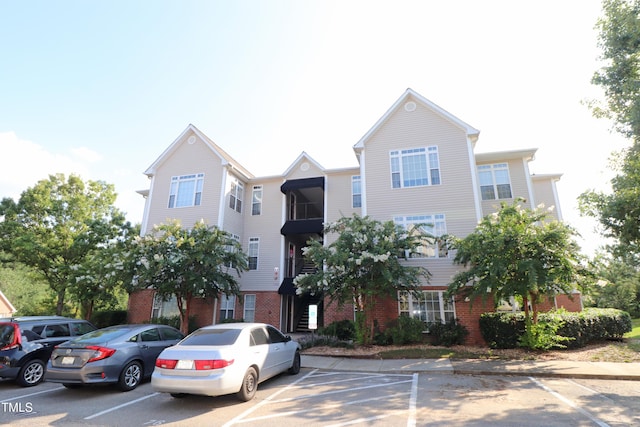 view of front of house featuring uncovered parking and brick siding