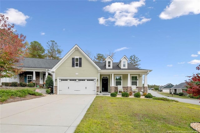 view of front of house with a porch, concrete driveway, stone siding, and a front lawn