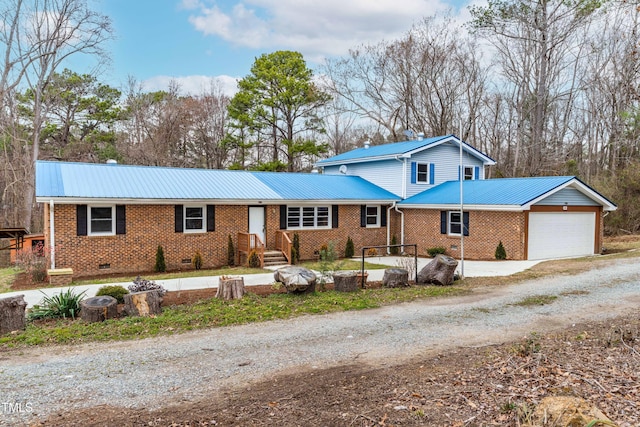 view of front of home featuring driveway, a garage, metal roof, crawl space, and brick siding