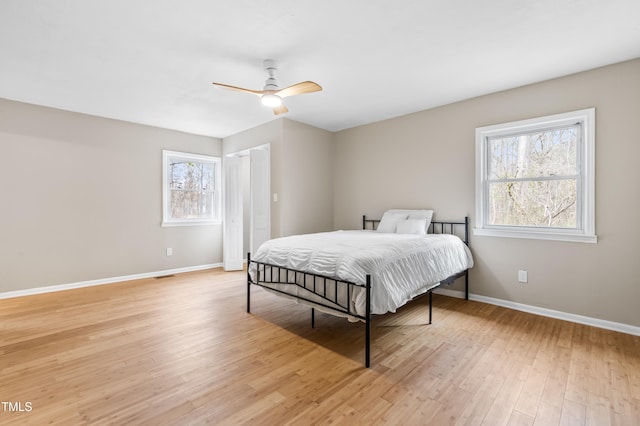 bedroom with a ceiling fan, visible vents, light wood-style flooring, and baseboards