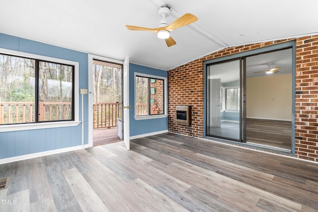 unfurnished sunroom with lofted ceiling with beams, ceiling fan, visible vents, and heating unit