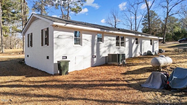 view of property exterior with crawl space, central AC, and brick siding