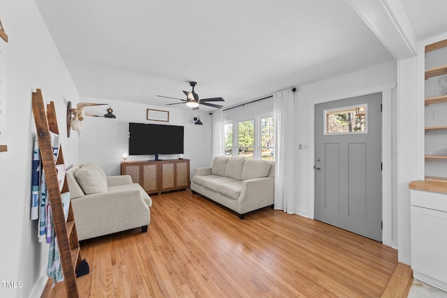 living room featuring light wood-style floors and a ceiling fan