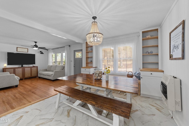 dining space featuring ceiling fan with notable chandelier, marble finish floor, built in shelves, and heating unit