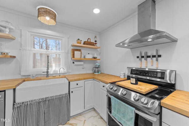 kitchen with butcher block countertops, appliances with stainless steel finishes, wall chimney exhaust hood, and open shelves