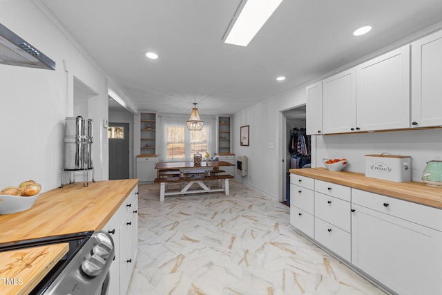 kitchen featuring stove, white cabinets, marble finish floor, wooden counters, and heating unit