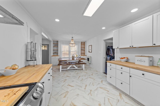 kitchen featuring marble finish floor, recessed lighting, butcher block counters, white cabinetry, and range