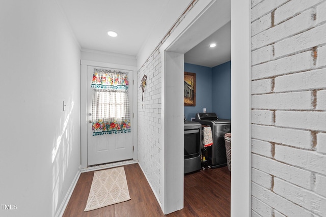 entryway with brick wall, baseboards, separate washer and dryer, and wood finished floors