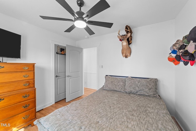 bedroom featuring light wood-style floors, baseboards, and a ceiling fan