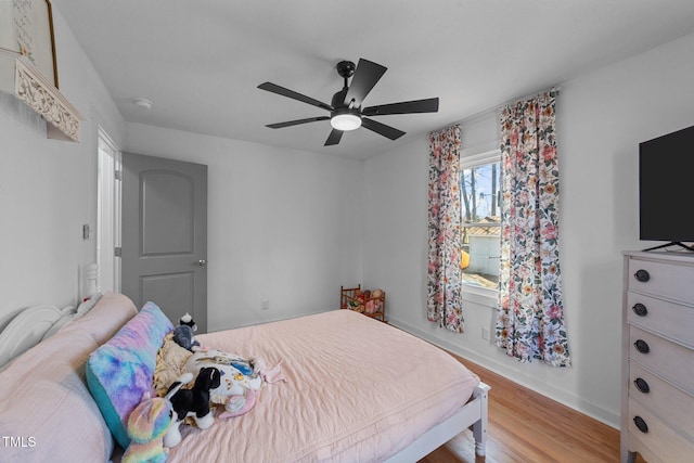 bedroom with ceiling fan, baseboards, and light wood-style floors