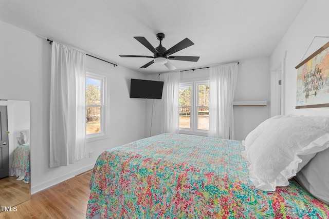 bedroom featuring a ceiling fan, a textured ceiling, and wood finished floors