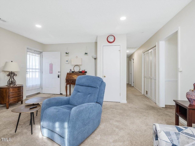 living room with recessed lighting and light carpet