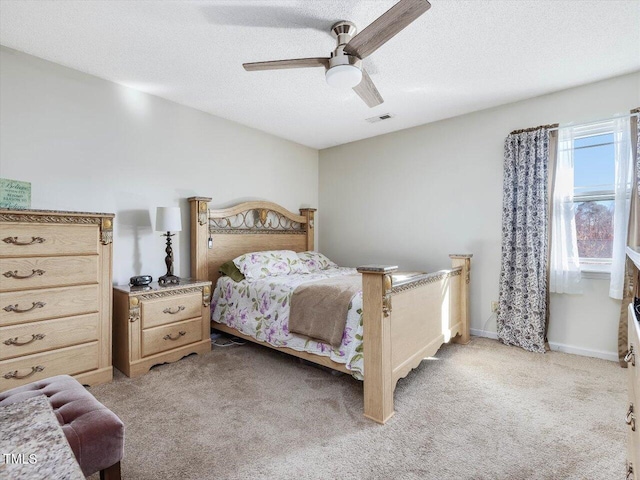 bedroom featuring visible vents, light colored carpet, a textured ceiling, and baseboards