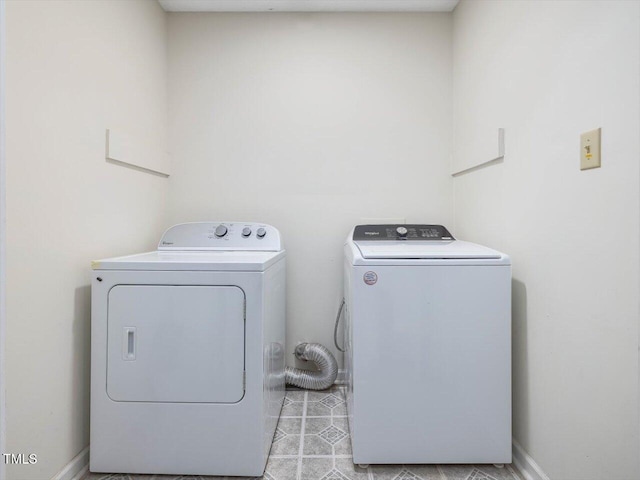 clothes washing area with laundry area, baseboards, and washer and clothes dryer