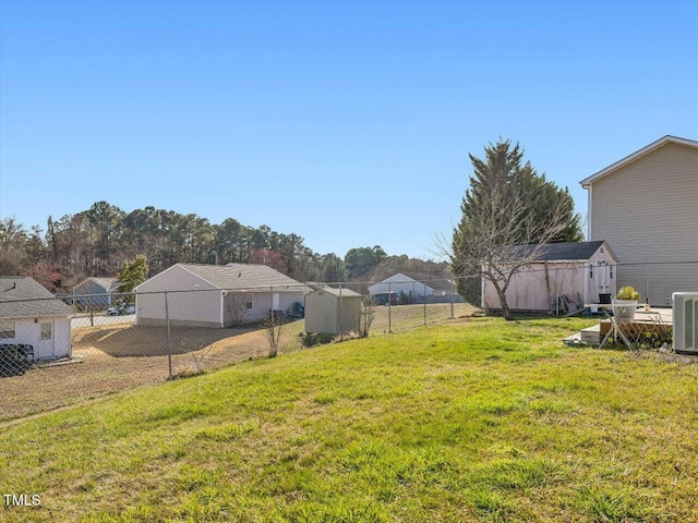 view of yard with a storage unit, cooling unit, an outdoor structure, and fence