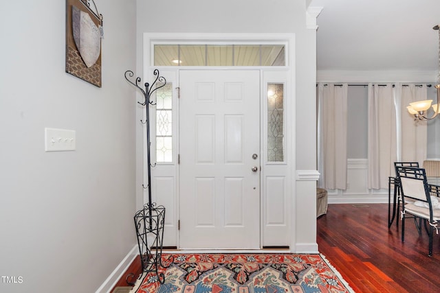 foyer featuring baseboards and wood finished floors