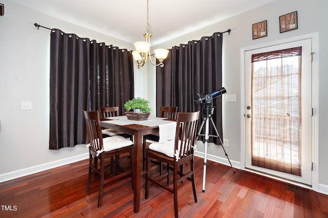 dining space featuring a notable chandelier, baseboards, and wood finished floors