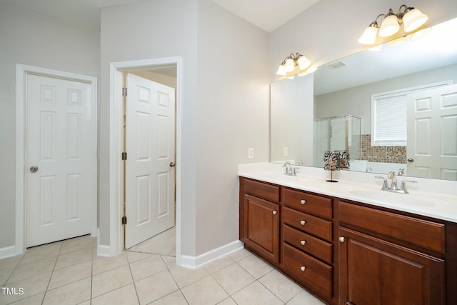 bathroom with a stall shower, a sink, and tile patterned floors