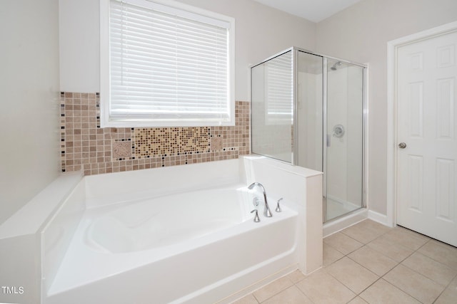 full bathroom featuring tile patterned flooring, a shower stall, and a bath