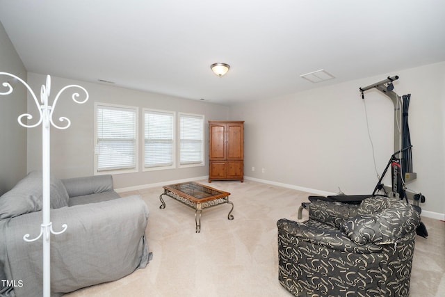 living area with light carpet, visible vents, and baseboards