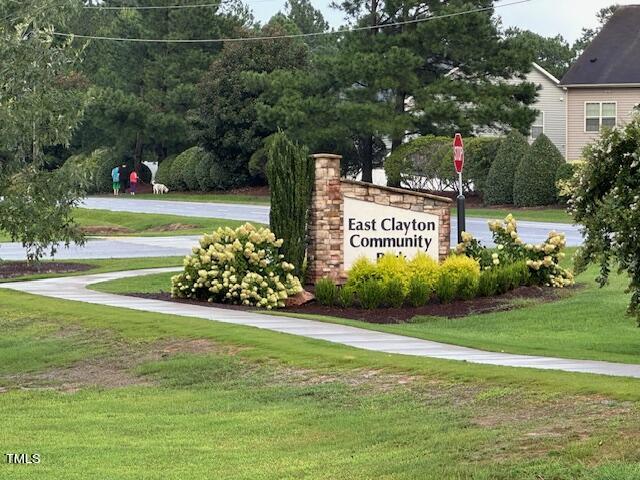 community / neighborhood sign featuring a lawn