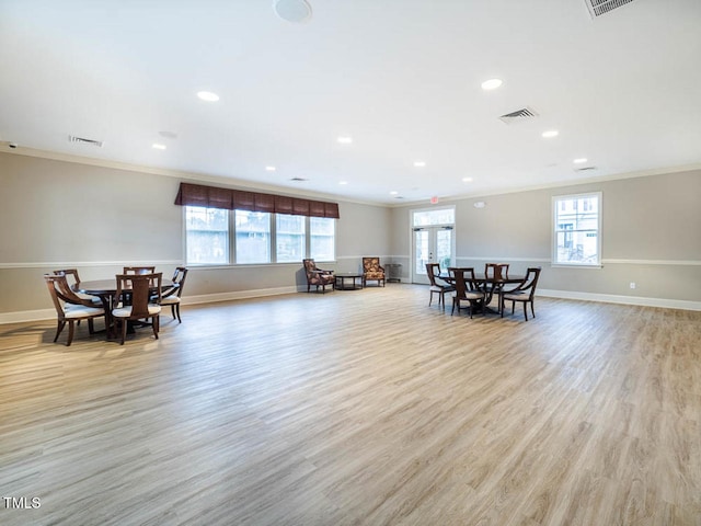 dining space featuring light wood-style flooring, visible vents, and crown molding