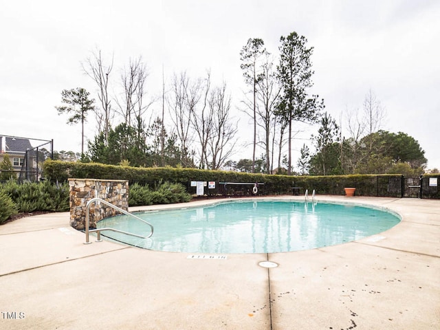 pool with fence and a patio