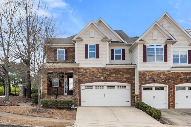 view of front of home with a garage, concrete driveway, and stone siding