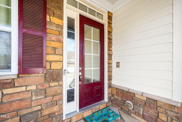 property entrance with covered porch and brick siding