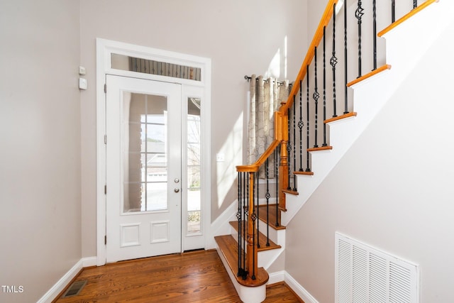 entrance foyer featuring baseboards, stairs, visible vents, and wood finished floors