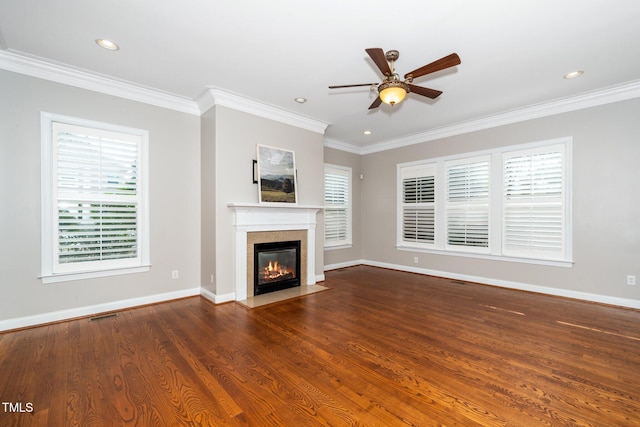 unfurnished living room featuring a fireplace with flush hearth, crown molding, baseboards, and wood finished floors