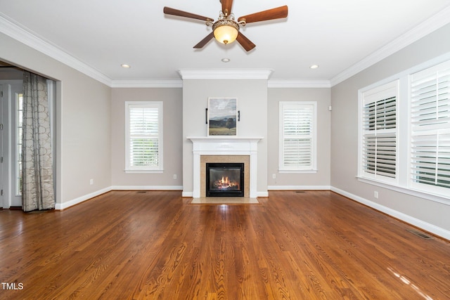 unfurnished living room with a fireplace with flush hearth, wood finished floors, visible vents, baseboards, and crown molding