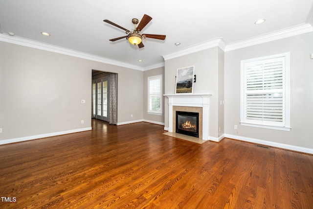 unfurnished living room featuring ornamental molding, baseboards, a fireplace with flush hearth, and wood finished floors