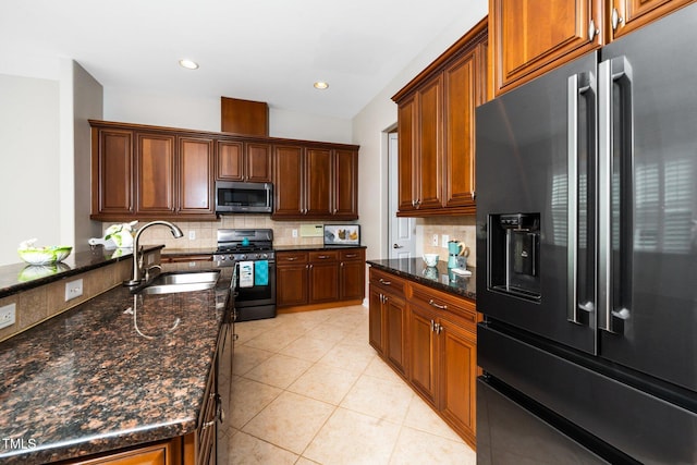 kitchen with light tile patterned floors, tasteful backsplash, appliances with stainless steel finishes, and a sink