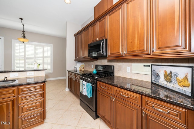 kitchen featuring brown cabinets, light tile patterned floors, backsplash, black range with gas stovetop, and dark stone countertops