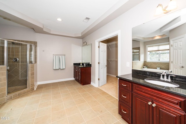 full bath with tile patterned flooring, two vanities, a sink, baseboards, and a stall shower