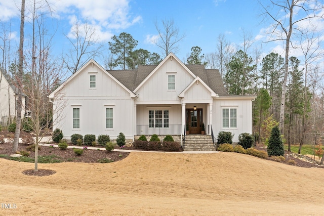 modern farmhouse with covered porch, board and batten siding, and a shingled roof