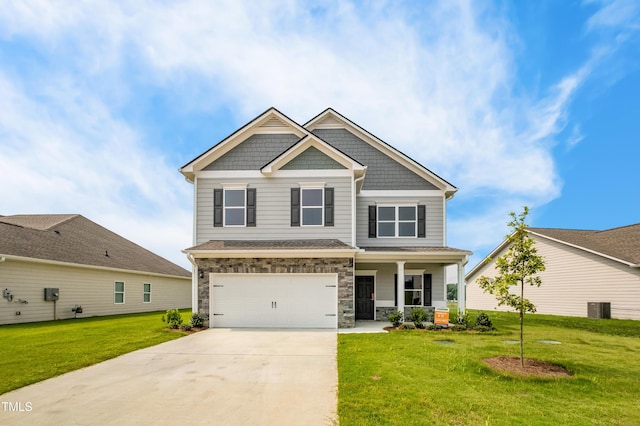 craftsman house featuring a porch, an attached garage, stone siding, driveway, and a front yard