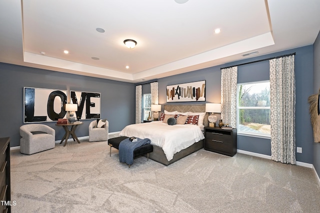 bedroom featuring carpet floors, a raised ceiling, visible vents, and baseboards