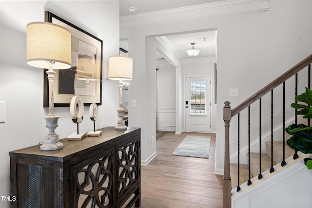 entryway with baseboards, stairway, wood finished floors, and crown molding